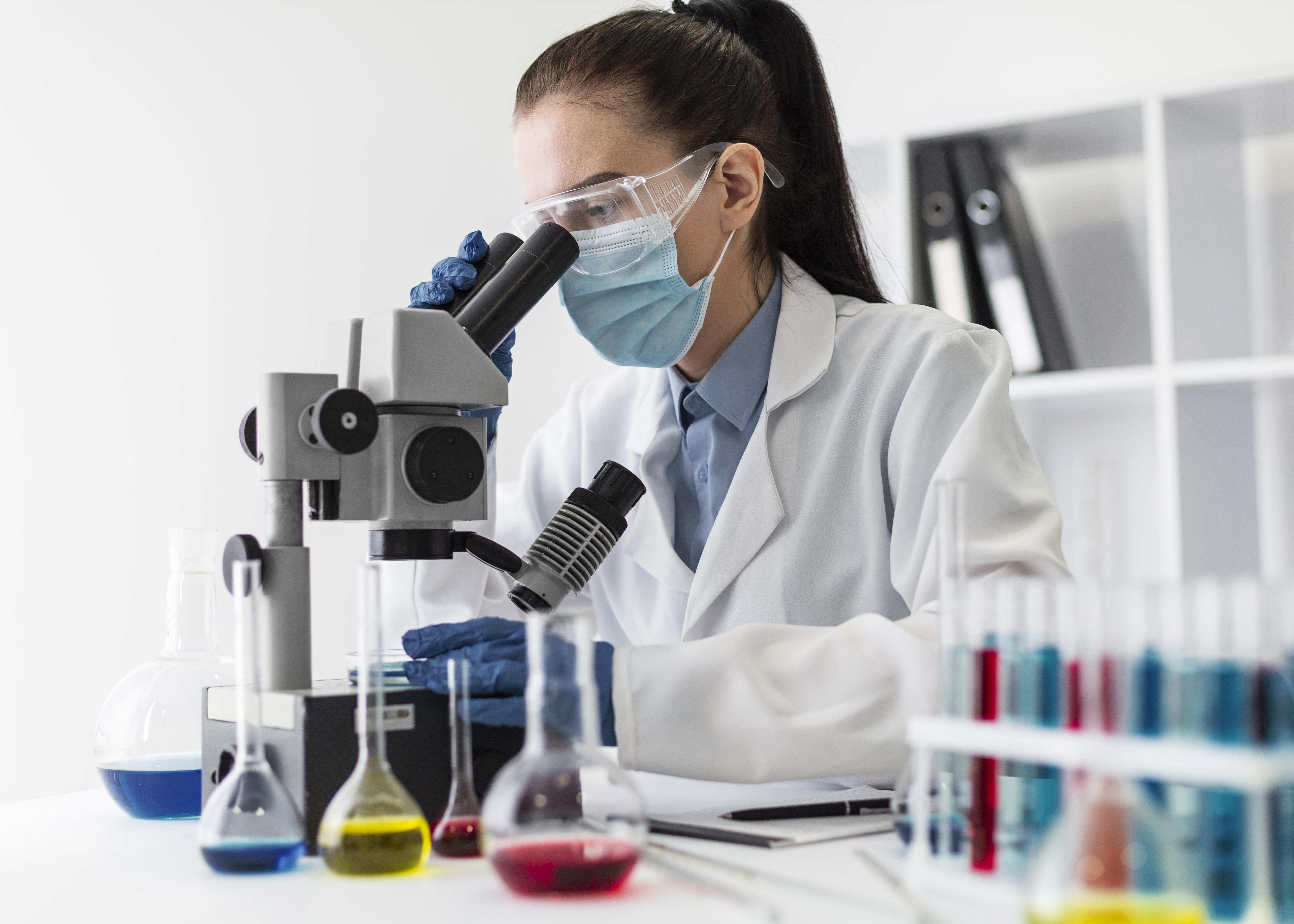 Gentek Lab technician examining a sample under a microscope